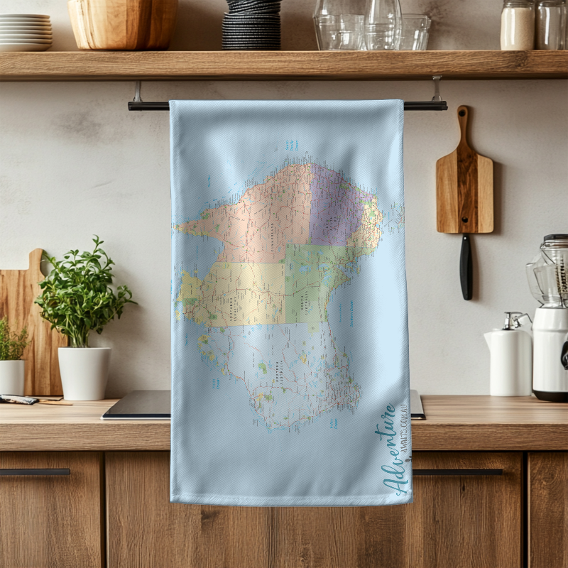Kitchen towel with a colorful map design hanging on a wooden rack.