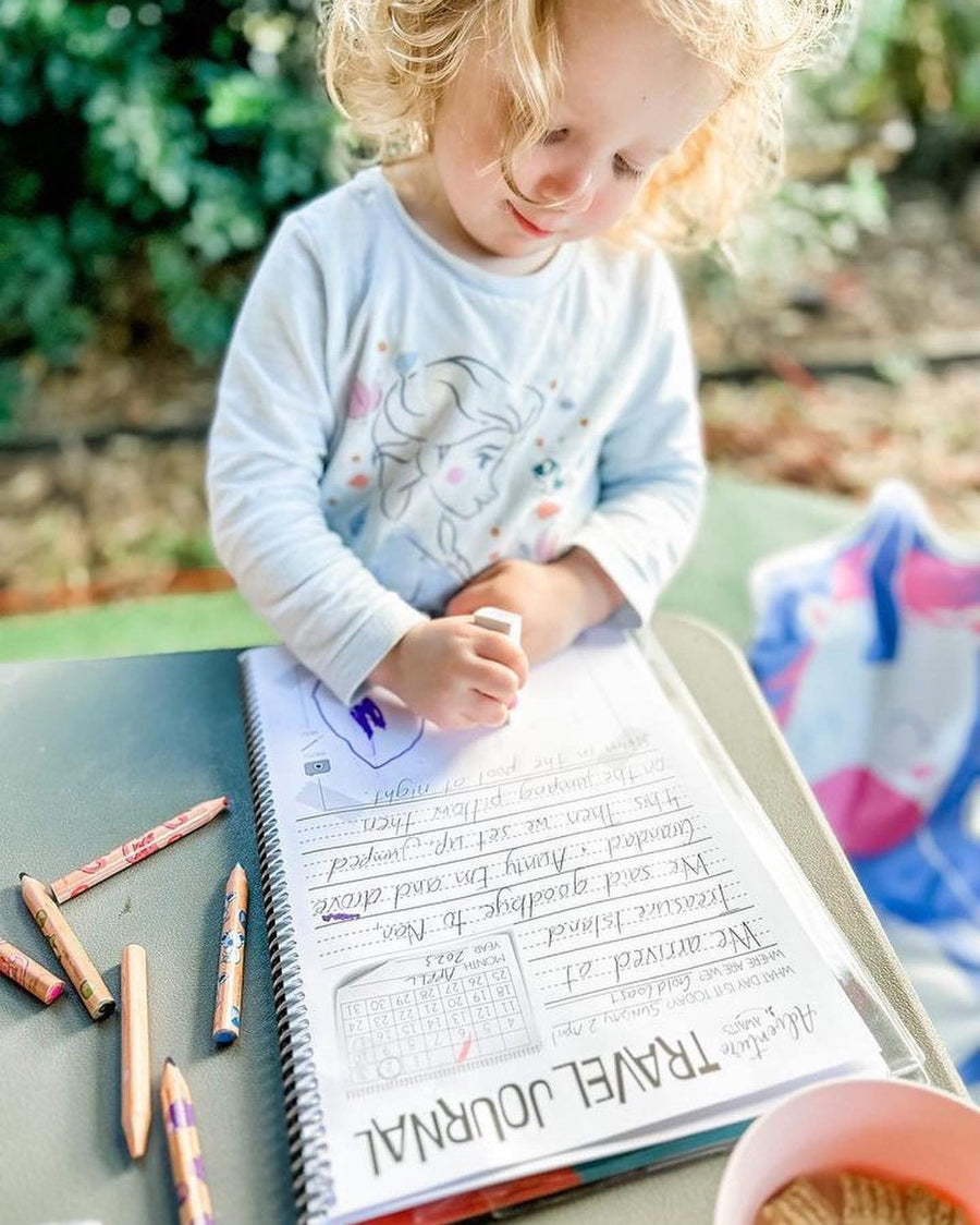 Young kid colouring in the kids travel journal