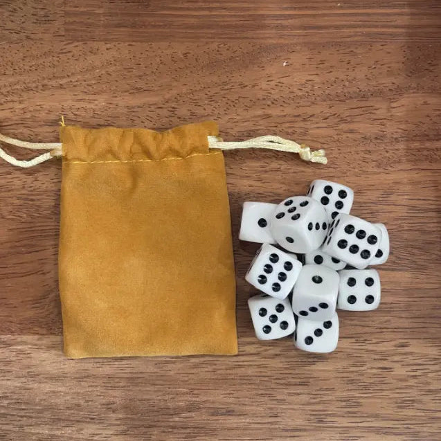 White dice set with black dots beside a mustard drawstring storage pouch — Adventure Awaits