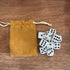 White dice set with black dots beside a mustard drawstring storage pouch — Adventure Awaits