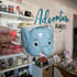 Blue elephant shaped mug held in a hand with a blurred background