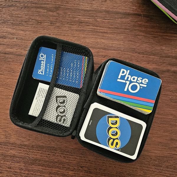Phase 10 and DOS cards in a black carrying case on a wooden surface