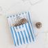 Reusable snack pouch with blue and white stripes holding energy balls, eco friendly food storage for snacks at home or travel Adventure Awaits