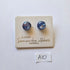 Pair of blue earrings on a glassblowing branded card with a white background
