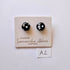 Black and white glass earrings on a branded card with 'Samantha Abbott' on a light gray background.