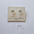 Pair of silver stud earrings on a branded card with 'Samantha Abbott' on a light gray background.