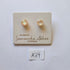 samantha abbott glass stud earrings Pair of pearl earrings on a branded card with a white background
