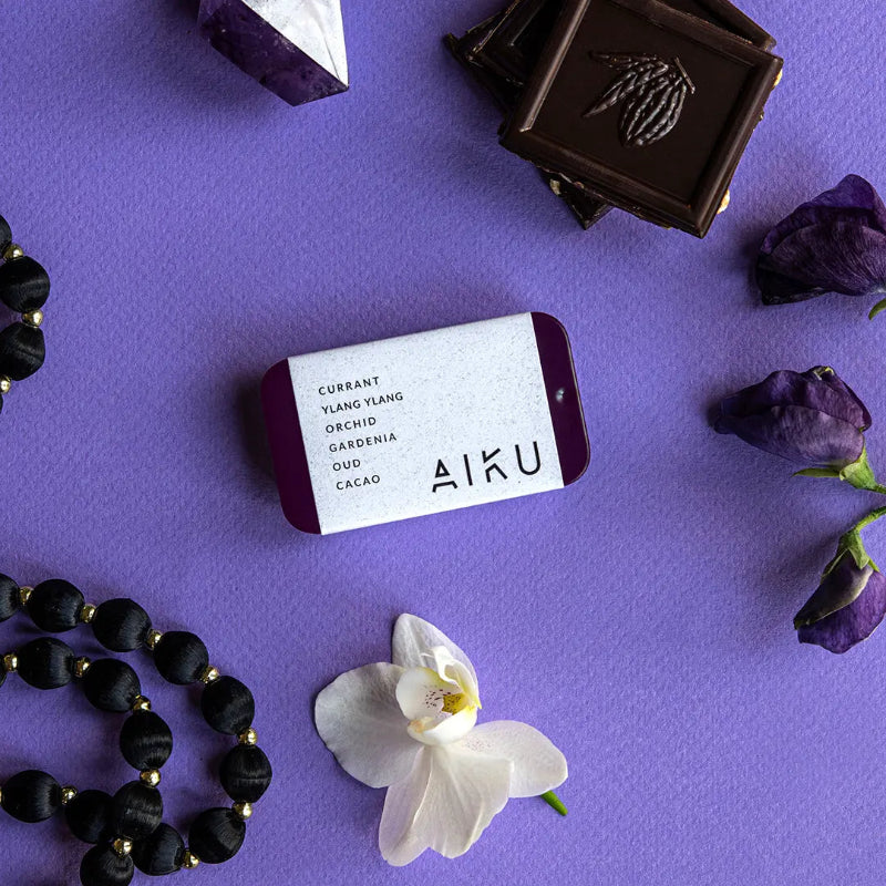 AIKU tin of solid perfume in Plume with coconut, ylang ylang, orchid, gardenia, oud and cacao notes — Adventure Awaits