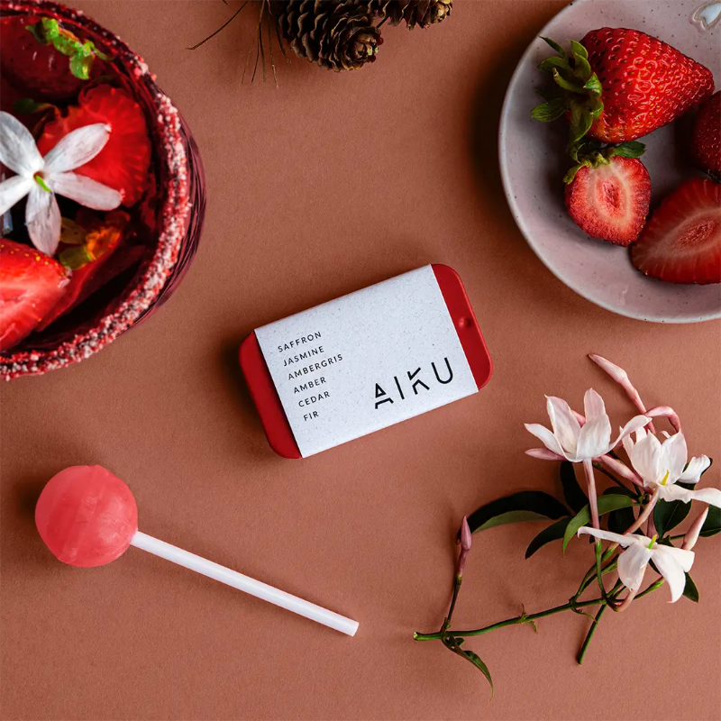 AIKU tin of solid perfume in Rosella with strawberries, jasmine flowers and a pink lollipop — Adventure Awaits