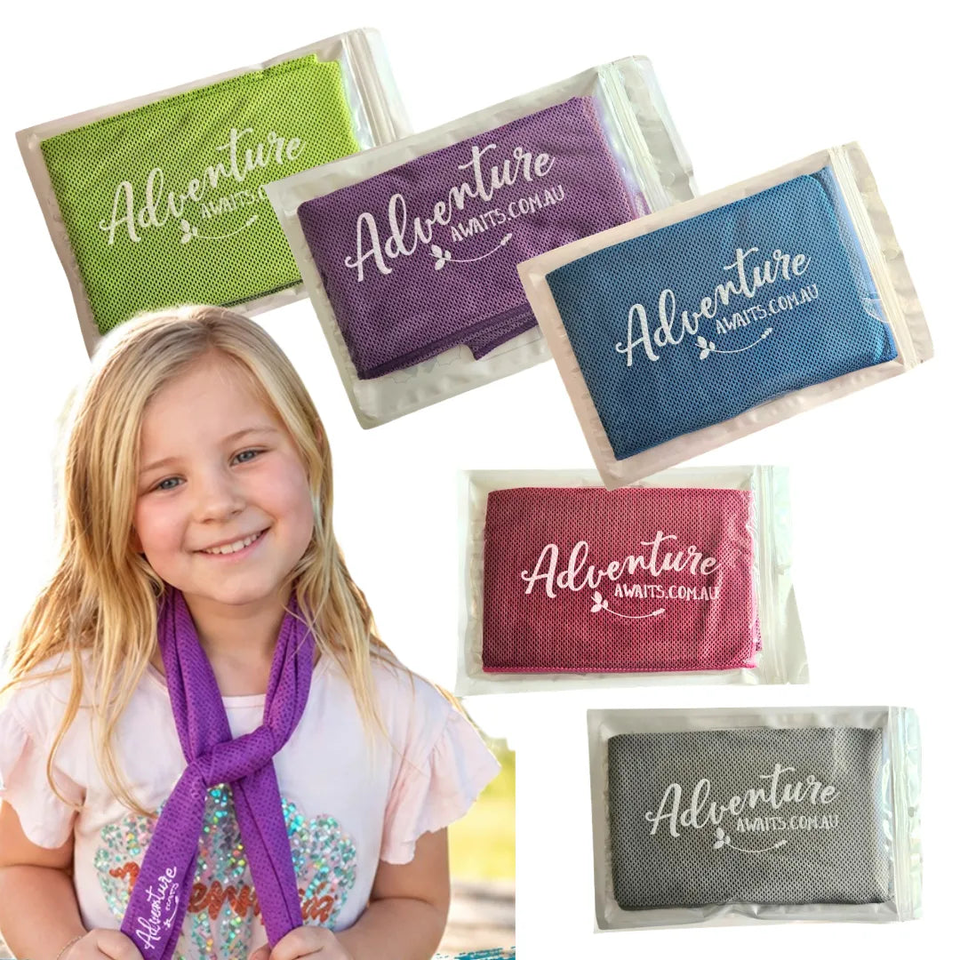 Adventure Awaits cooling towels in blue, purple, green, pink and grey, displayed alongside a smiling child wearing a purple cooling towel around her neck.