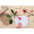 Hand placing a red flower inside the Australian Flora wooden flower press on a craft table, Adventure Awaits