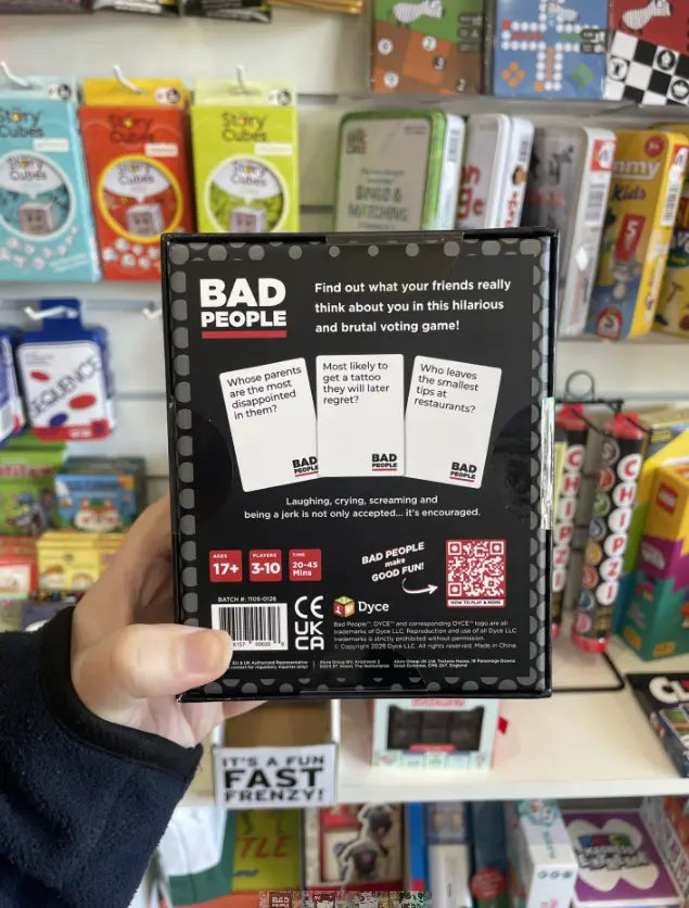 Back of Bad People party game box held in store with cheeky card examples Adventure Awaits