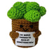 handmade crochet broccoli plush toy in a pot holding a funny motivational sign about trying something new
