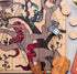 Close-up of Australian timber snakes and ladders board with native animal counters and wooden dice — Adventure Awaits