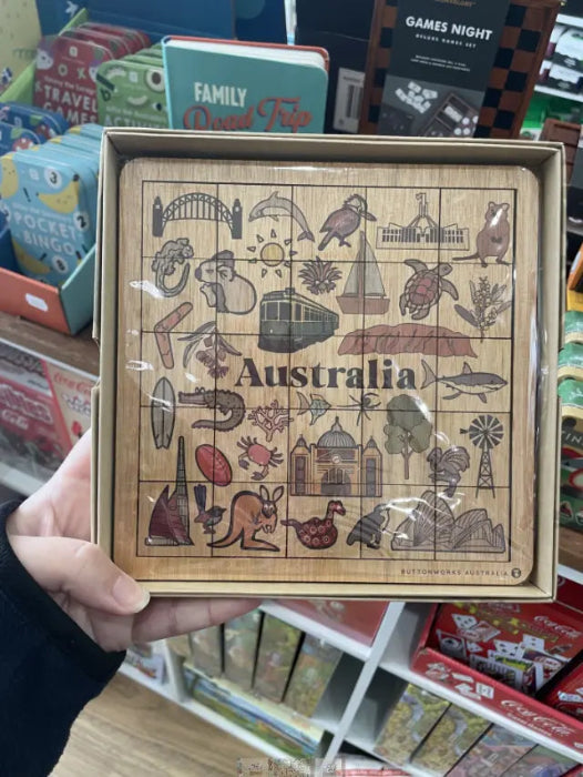 Hand holding an Australian Icons timber puzzle with native animals, landmarks and symbols — Adventure Awaits