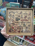 Hand holding an Australian Icons timber puzzle with native animals, landmarks and symbols — Adventure Awaits