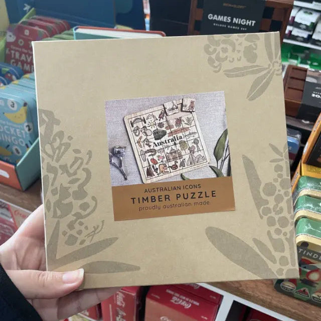 Hand holding an Australian Icons timber puzzle gift box marked proudly Australian made — Adventure Awaits