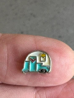 Vintage caravan keepsake charm in teal and cream enamel held in fingers to show its small size — Adventure Awaits