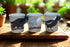 Three ceramic cups with animal designs on a wooden surface.