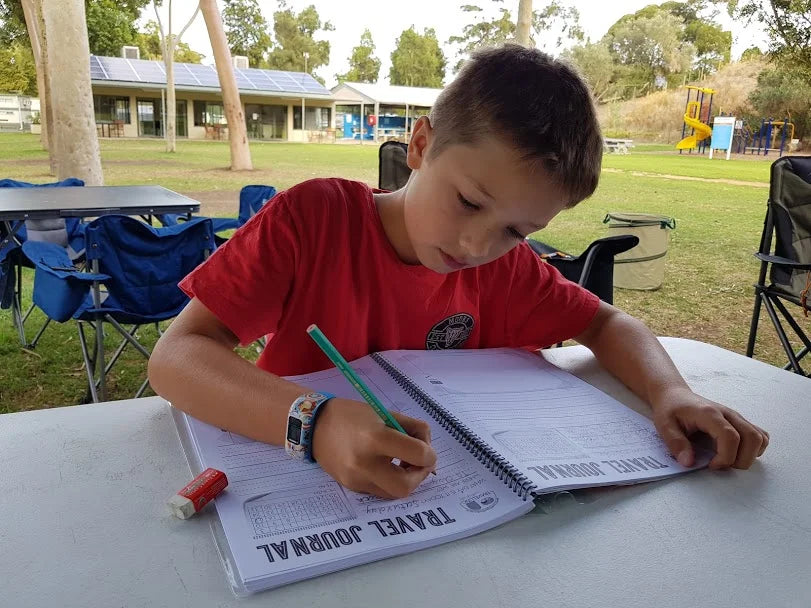 Little boy filling out the kids travel journal 