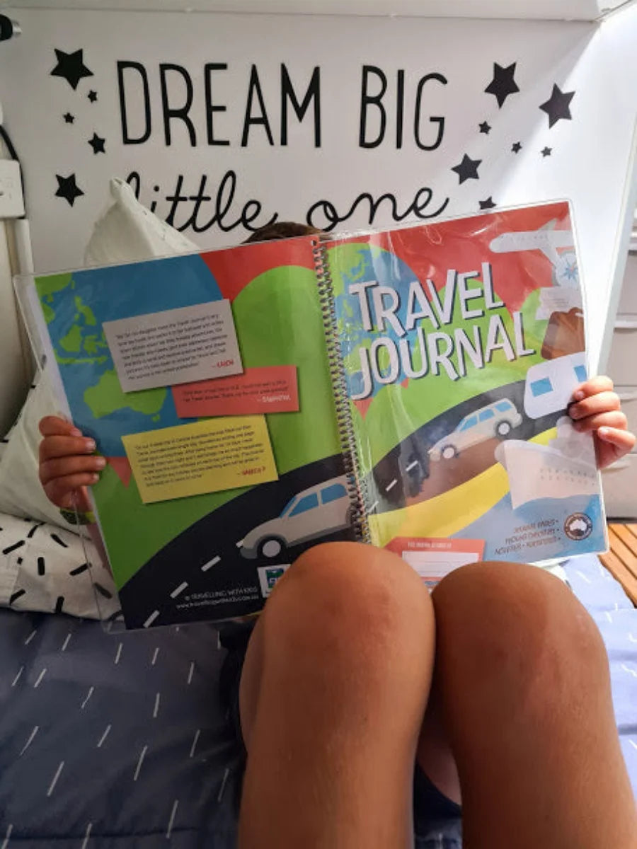 Young kid reading about their travels in the Kids Travel Journal 