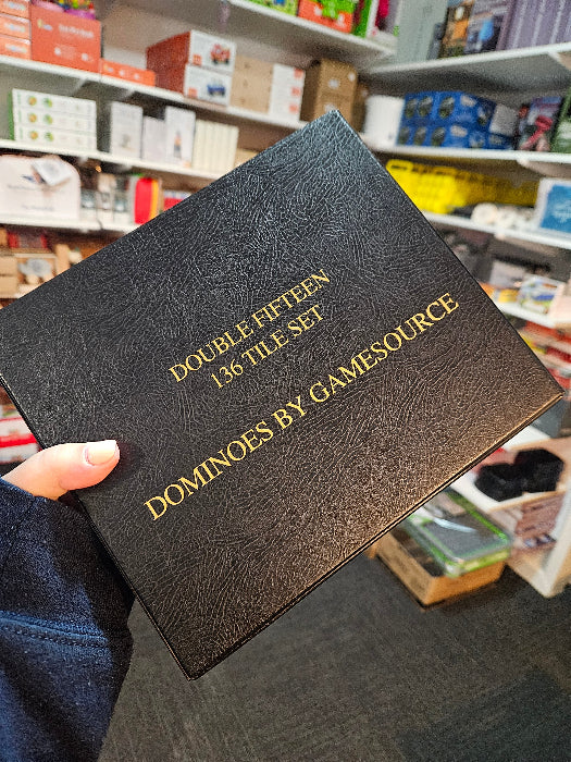 Hand holding a black Gamesource Double Fifteen 136 tile domino set case in store — Adventure Awaits