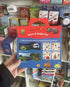 Back of Happy Campers reusable cling sticker book held in store — Adventure Awaits