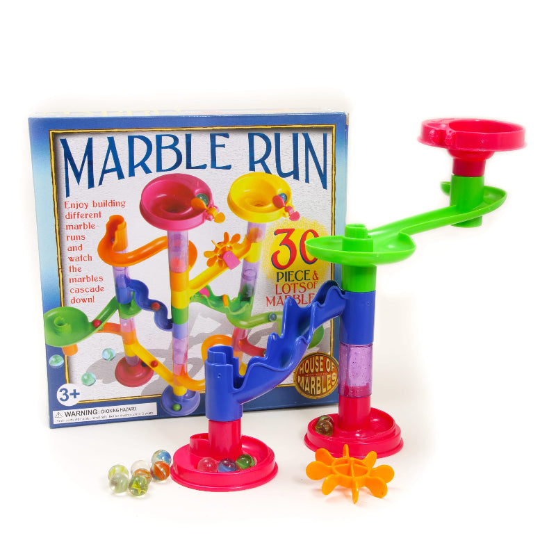 Colourful assembled marble run with towers, funnels, curved tracks and marbles in front of box — Adventure Awaits