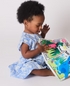 A child playing with Jo and Nics Crinkly Cloth Baby Books.