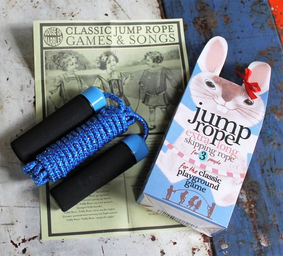 Jump rope with blue handles and packaging on a rustic surface