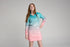 Girl wearing an aqua and pink long-sleeve UPF50+ fishing dress against a plain backdrop — Adventure Awaits