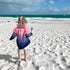 Girl walking barefoot on a beach in a pink and blue Mermaid Life fishing shirt, holding an ice cream — Adventure Awaits