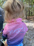 Back view of child in a pink and navy Mermaid Life long-sleeve fishing shirt at a bush campsite — Adventure Awaits