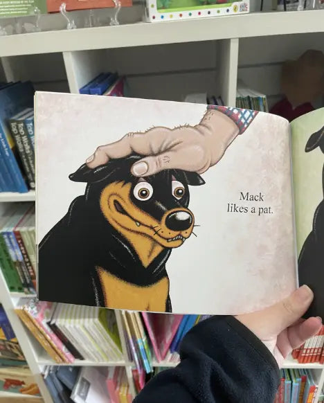 Mack Loves Cow Poo! kids book page with Mack getting a pat from a hand Adventure Awaits