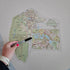 Hand holding a marker over a map of Australia on a white surface