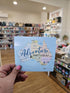 Map of Australia with 'Adventure Awaits.com.au' text held in a store setting
