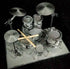 Completed Metal Earth silver steel drum set model viewed from above with drumsticks across the drums, Adventure Awaits