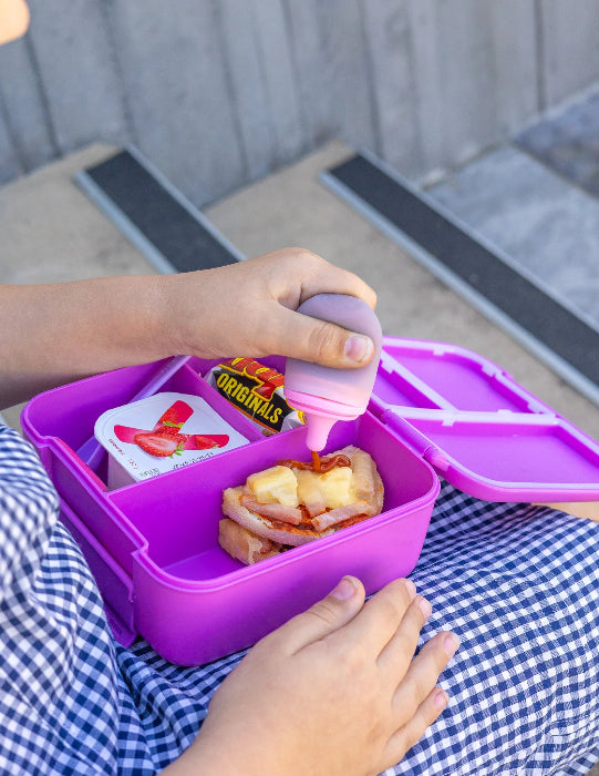 Silicone sauce bottle with lunch box containing food