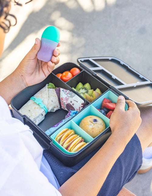 Silicone sauce bottle with lunch box containing food