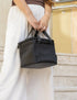 Woman carrying a black insulated lunch bag with short handles and front pocket — Adventure Awaits