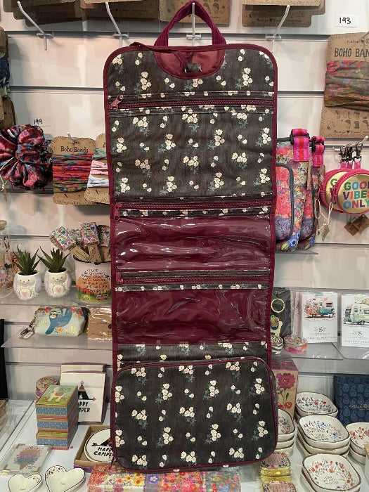Hanging floral travel toiletry organiser with multiple clear zip compartments and burgundy trim