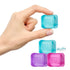 A hand holds a translucent light blue Needoh Nice Ice Baby Cube - Adventure Awaits