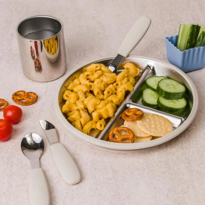 Kids lunch served in a stainless steel divided plate with pasta, cucumber and crackers, Adventure Awaits
