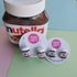 Mini Nutella jar stud and drop earrings displayed beside a large Nutella jar, Adventure Awaits