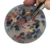 close up of stones being extracted with tweezers from silicone pick 'em disc