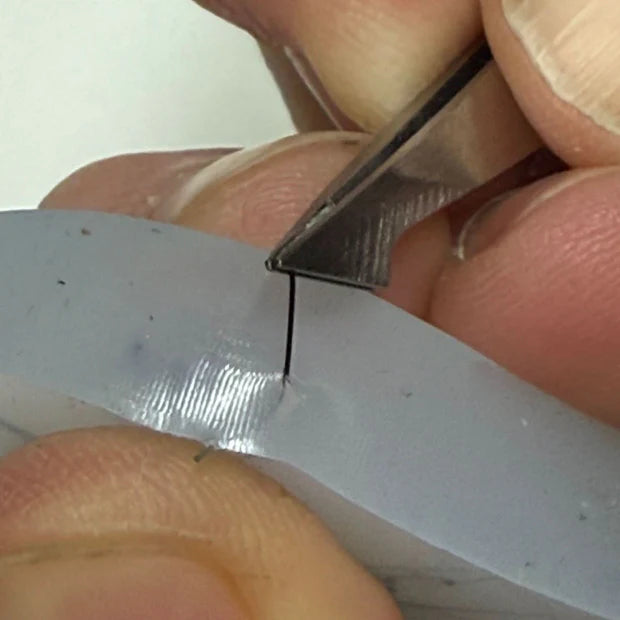close up of fibres being extracted with tweezers from edge of silicone pick 'em disc