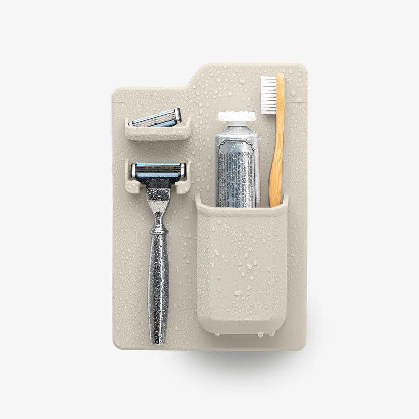 Cream shower organiser with razor holders, toothbrush cup and water droplets — Adventure Awaits