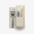 Cream shower organiser with razor holders, toothbrush cup and water droplets — Adventure Awaits