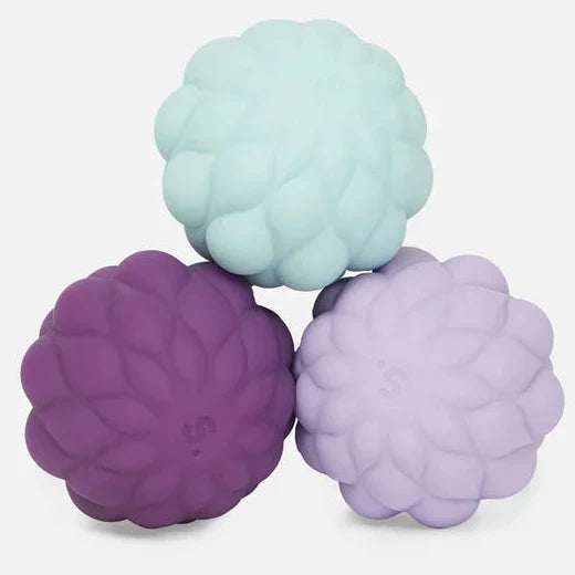 Three textured, raspberry-shaped silicone massage balls in mint green, purple, and lavender, arranged on a light gray background.