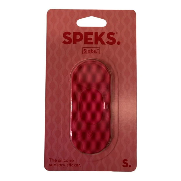 A red oval-shaped silicone sensory sticker by SPEKS. Slabs, shown in its original red cardboard blister packaging against a white background.